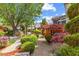 Landscaped garden with brick path, mature trees, and vibrant flower beds creating a serene retreat at 1012 Delta River Way, Knightdale, NC 27545