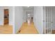 Spacious hallway featuring hardwood floors, white walls, and views into the kitchen and living area at 1012 Delta River Way, Knightdale, NC 27545