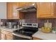 This kitchen shows dark backsplash, wooden cabinets, stainless steel appliances and countertops at 1012 Delta River Way, Knightdale, NC 27545