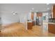 A spacious kitchen with stainless steel appliances, wood cabinets, and hardwood floors connects to a large living area at 1012 Delta River Way, Knightdale, NC 27545