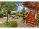 Brick patio with fire pit and wooden staircase surrounded by lush landscaping, perfect for outdoor living at 1012 Delta River Way, Knightdale, NC 27545
