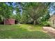 Large backyard with a storage shed, ample green space, and a concrete patio area at 103 Val Del Ct, Garner, NC 27529