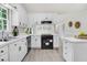 Renovated kitchen featuring white cabinets, modern black appliances, and ample countertop space at 103 Val Del Ct, Garner, NC 27529