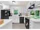 The remodeled kitchen offers white cabinets, a black refrigerator, and views of the backyard at 103 Val Del Ct, Garner, NC 27529