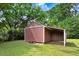 Backyard featuring a wooden storage shed with an open lean-to, perfect for yard equipment at 103 Val Del Ct, Garner, NC 27529