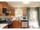 Well-equipped kitchen featuring wooden cabinets, modern appliances, and a sunlit window at 103 Westview # H, Carrboro, NC 27510