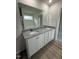 Bathroom featuring a double sink vanity, granite countertop, and wood-look flooring at 104 Oakfield Trace Dr, Four Oaks, NC 27524
