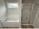 Bathroom featuring a soaking tub and glass-enclosed shower at 104 Oakfield Trace Dr, Four Oaks, NC 27524