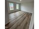 Bright bedroom features two windows and modern flooring, creating a cozy and inviting atmosphere at 104 Oakfield Trace Dr, Four Oaks, NC 27524