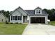 Charming single-Gathering home with gray siding, black shutters, an attached garage, and a well-manicured lawn at 104 Oakfield Trace Dr, Four Oaks, NC 27524