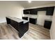 Modern kitchen with dark cabinetry, a granite breakfast bar, stainless steel appliances, and sleek finishes at 104 Oakfield Trace Dr, Four Oaks, NC 27524