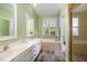 Bright bathroom featuring double sinks, white vanity and cabinets, a bathtub and separate shower at 109 Jasmine Rose Ct, Holly Springs, NC 27540