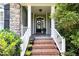 Inviting front porch with brick steps, white railings, and decorative plants at 109 Jasmine Rose Ct, Holly Springs, NC 27540