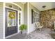 Covered porch featuring stone accents, bench seating, and stylish front door at 109 Jasmine Rose Ct, Holly Springs, NC 27540