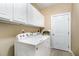 Practical laundry room featuring white washer and dryer set with overhead cabinets for ample storage at 109 Jasmine Rose Ct, Holly Springs, NC 27540