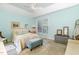 Comfortable main bedroom with a tray ceiling, ceiling fan, large window and soothing blue walls at 109 Jasmine Rose Ct, Holly Springs, NC 27540