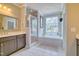 Bright bathroom with a tub, walk-in shower, dual vanity, and large window at 1161 Golden Star Way, Wake Forest, NC 27587