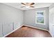 This bedroom features wood floors, a ceiling fan, and a window for natural light at 117 Brierridge Dr, Apex, NC 27502