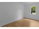 Light-filled bedroom features new floors, white trim, and a pleasant window view at 1204 Pecan Pl, Durham, NC 27704