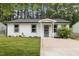 Charming white home with a well-manicured lawn and a cozy, inviting entrance with decorative door at 1204 Pecan Pl, Durham, NC 27704