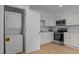Bright kitchen features white cabinets, stainless steel appliances and in-unit washer and dryer at 1204 Pecan Pl, Durham, NC 27704