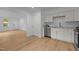 Bright kitchen with stainless steel appliances, white cabinets, hardwood floors, and an adjoining living area at 1204 Pecan Pl, Durham, NC 27704