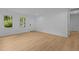An open room, flooded with light, showcases the natural wood flooring at 1204 Pecan Pl, Durham, NC 27704