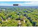 An aerial view of a property surrounded by lush trees and landscaping, with a clear blue sky above at 1209 Locharron Ln, Cary, NC 27511