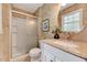 Bathroom with granite countertop, decorative mirror, and tiled shower with glass door at 1209 Locharron Ln, Cary, NC 27511