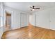 Bright bedroom featuring hardwood floors and a ceiling fan with attached bathroom at 1209 Locharron Ln, Cary, NC 27511