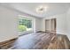 Open living room featuring wood flooring and a large window overlooking lush greenery at 1209 Locharron Ln, Cary, NC 27511