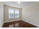 Cozy bedroom featuring hardwood floors, neutral walls, and a window with blinds for natural light at 125 Durban Meadow Dr, Holly Springs, NC 27540