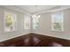 Open dining room showcasing hardwood floors, a chandelier, and large windows for abundant light at 125 Durban Meadow Dr, Holly Springs, NC 27540