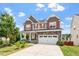 Charming two-story home featuring a two-car garage, manicured lawn, and inviting front porch at 125 Durban Meadow Dr, Holly Springs, NC 27540