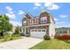 Inviting two-story home with stone accents, a two-car garage, and a well-maintained front yard at 125 Durban Meadow Dr, Holly Springs, NC 27540