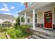 Charming front porch with stone steps, white columns, and a welcoming red front door at 125 Durban Meadow Dr, Holly Springs, NC 27540
