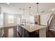 A kitchen island with sink in an open floor plan with brick fireplace and staircase at 125 Durban Meadow Dr, Holly Springs, NC 27540