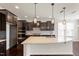 A kitchen with dark cabinetry, a large island with granite countertops, and pendant lights at 125 Durban Meadow Dr, Holly Springs, NC 27540