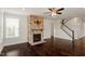 A living room with a stone fireplace, a ceiling fan, and staircase to upper level at 125 Durban Meadow Dr, Holly Springs, NC 27540