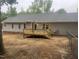 Backyard featuring a newly built deck, gray vinyl siding, and fenced yard with mature trees at 125 Tast Dr, Wendell, NC 27591