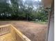 A backyard with a new wood deck and freshly cleared, large backyard with chain link fence and a shed at 125 Tast Dr, Wendell, NC 27591
