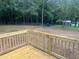A new wood deck overlooks a large backyard with chain link fence, shed, and wooded background at 125 Tast Dr, Wendell, NC 27591