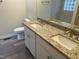 Bathroom with double granite vanity, modern fixtures, and wood-look vinyl flooring at 125 Tast Dr, Wendell, NC 27591