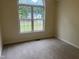 A bright bedroom featuring a large window, neutral walls, and plush carpeting at 125 Tast Dr, Wendell, NC 27591