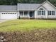 Charming single-story home featuring a blue front door, gray siding, and an attached two-car garage at 125 Tast Dr, Wendell, NC 27591