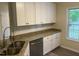 A kitchen with stainless-steel appliances, granite counters, and a double sink overlooking the yard at 125 Tast Dr, Wendell, NC 27591