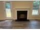 A living room with wood flooring, a fireplace, door to the backyard deck, and a window at 125 Tast Dr, Wendell, NC 27591
