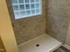 Tiled shower with a glass block window for added privacy and natural light at 125 Tast Dr, Wendell, NC 27591