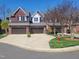 Brick townhouses with two-car garages showcasing symmetrical design and well-kept front yards at 129 Grande Dr, Morrisville, NC 27560