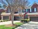 Charming townhouse exterior featuring brick facade, a two-car garage, and manicured landscaping at 129 Grande Dr, Morrisville, NC 27560